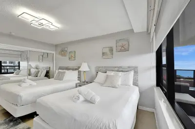 two white beds in a room with a window at Breathtaking 2 Bedroom Condo w Beach Service 919 in Miami Beach