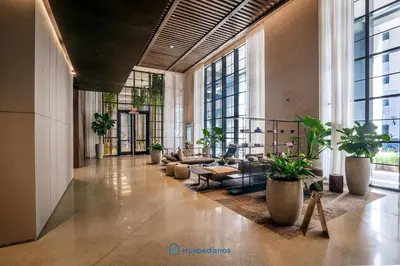a living room with a large lobby with potted plants at Apartment in New Luxury Condo in Downtown in Miami