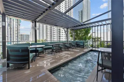 a rooftop patio with tables and chairs and a pool at La Terrasse by VIAC - Luxury Bay View Studio with Balcony 29th Floor Miami in Miami
