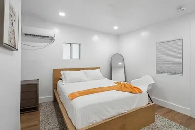 a white bedroom with a bed and a mirror at Casa Roselle # 3 in Hollywood