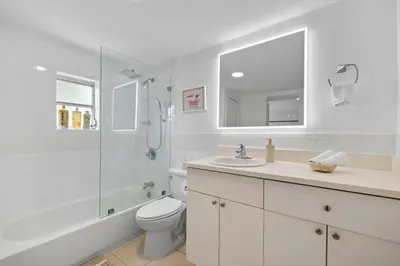 a white bathroom with a toilet and a shower at La Casita by TilahStays in Miami