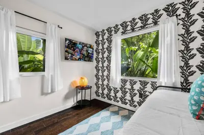 a bedroom with a bed and two windows at Miami Hidden Garden by TilahStays in Miami