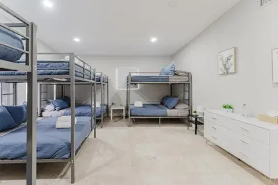 a room with three bunk beds with blue sheets at Beautiful Aventura Villa Sleeps 26 in Miami
