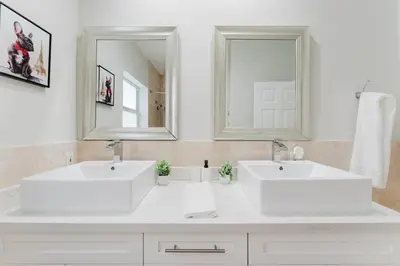 a white bathroom with two sinks and a mirror at Beautiful Aventura Villa Sleeps 26 in Miami