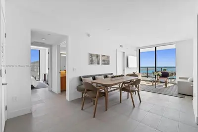 a dining room and living room with a table and chairs at Panoramic Ocean View 3 bedroom Nativo Pool Gym SPA in Miami