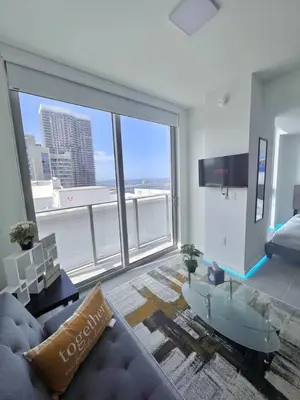 a living room with a couch and a large window at Ocean View Entire Condo In Downtown With Pool and Gym in Miami