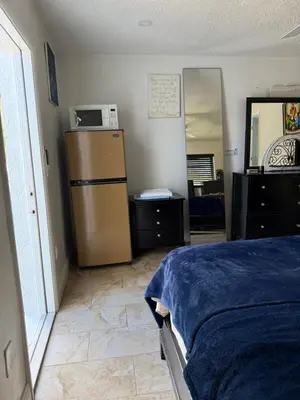 a bedroom with a bed and a refrigerator and a mirror at My Garden in Miami Florida in Palmetto Bay