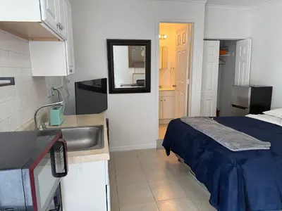 a kitchen with a sink and a bed in a room at My Garden in Miami Florida in Palmetto Bay