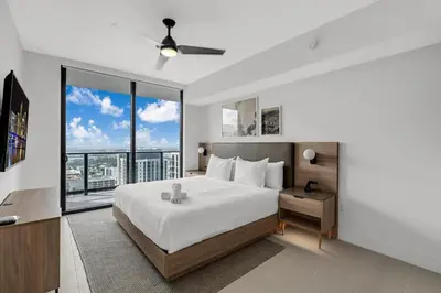 a bedroom with a large bed and a large window at Stylish City Getaway with Pool Skyline Views in Miami