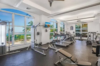 a gym with treadmills and cardio equipment and windows at Fantastic Townhouse Beach Access Resort Amenities! in Hallandale Beach