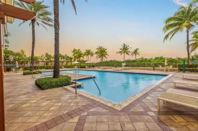 a pool at a resort with palm trees at Fantastic Townhouse Beach Access Resort Amenities! in Hallandale Beach