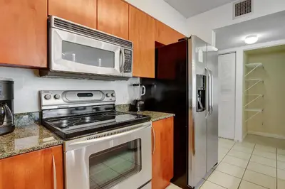 a kitchen with a stove and a microwave at Bay View Condo, Sleeps 6, Pool, Spa, Gym and Games in Miami