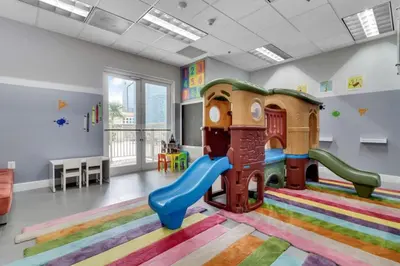 a childrens play room with a slide and a playground at Bay View Condo, Sleeps 6, Pool, Spa, Gym and Games in Miami
