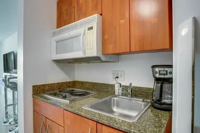 a kitchen with a sink and a microwave at Modern Studio with Balcony, Pool, Gym and Games in Miami