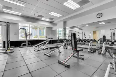 a gym with several tread machines and a clock at Fall in love with Brickell - Your Miami home in Miami