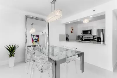a dining room with a glass table and chairs at Magnificent Ocean Sky Residence in Miami