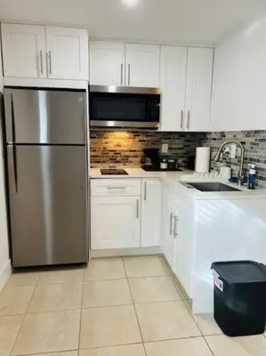 a kitchen with white cabinets and a stainless steel refrigerator at Sunshine Cove in Lake Forest