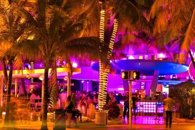 a group of people standing in front of a building with purple lights at Wynwood Miami Family Oasis in Miami