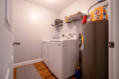 a kitchen with a washer and dryer next to a refrigerator at House Genesis in Homestead