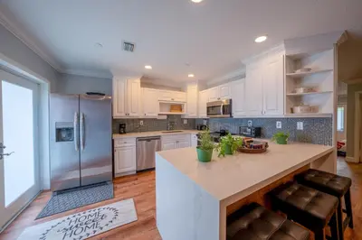 a kitchen with white cabinets and a refrigerator at House Genesis in Homestead
