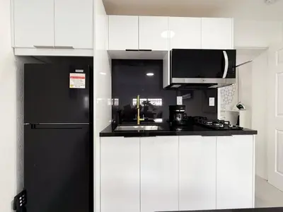 a kitchen with white cabinets and a black refrigerator at Central King Studio Quiet & Close to Hard Rock in Miami Gardens