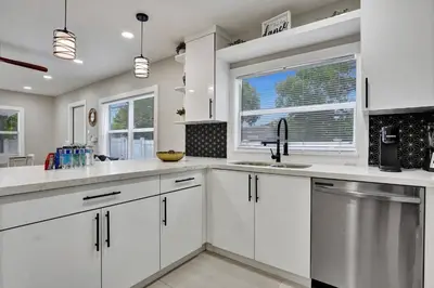 a kitchen with white cabinets and a sink and a window at Hollywood Lux Retreat in Hollywood