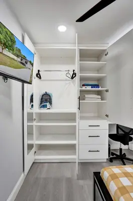 a bedroom with white shelves and a tv at Hollywood Lux Retreat in Hollywood