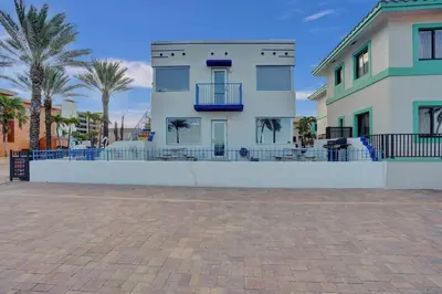 a white building with palm trees in front of it at Sunset Oceanfront Retreat in Hollywood