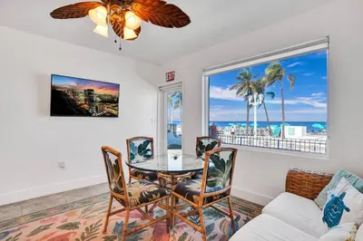 a dining room with a table and chairs and a couch at Sunset Oceanfront Retreat in Hollywood