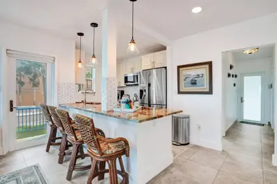 a kitchen with a counter and chairs in a room at Sunset Oceanfront Villa in Hollywood