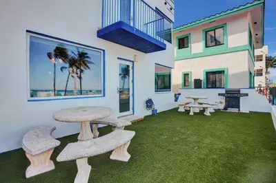 a group of picnic tables and benches in a yard at Sunset Oceanfront Villa in Hollywood