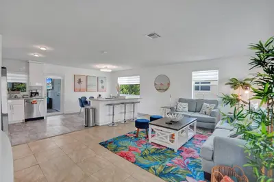 a living room with a couch and a kitchen at Coastal Breeze Retreat in Pembroke Pines