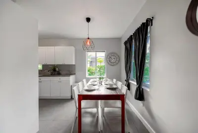 a dining room with a red table and white chairs at Spacious East Miami Duplex Delightful in Miami