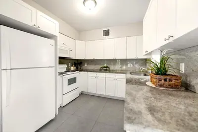 a kitchen with white cabinets and a white refrigerator at Spacious East Miami Duplex Delightful in Miami