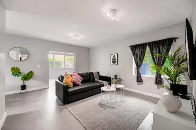 a living room with a black couch and a table at Spacious East Miami Duplex Delightful in Miami