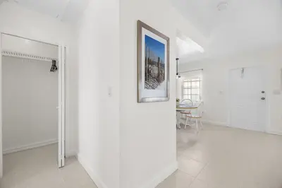 a white room with a picture on the wall at Sunset Inn - Hallandale Beach in Hallandale Beach