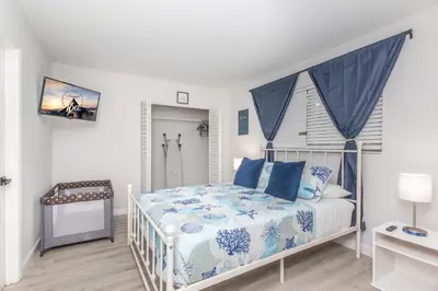 a white bedroom with a bed with blue pillows at Beachside Parking - Las Olas, Airport, Port Evg in Fort Lauderdale