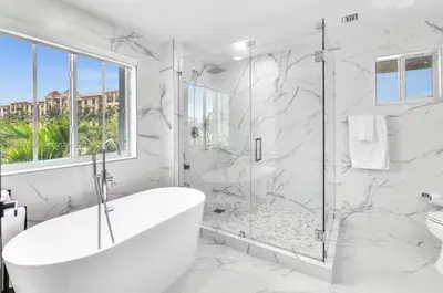 a white bathroom with a tub and a shower at Casa Olympus Fort Lauderdale - Walk to the Beach! in Fort Lauderdale