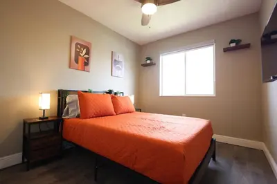 a bedroom with an orange bed and a window at Walk to Stadium - 3BR King Bed Haven - Parking in Miami Gardens