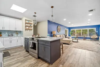 a kitchen with white cabinets and blue walls at 3-Bedroom Villa with Heated Pool and Tropical Yard in Hollywood Lakes in Hollywood