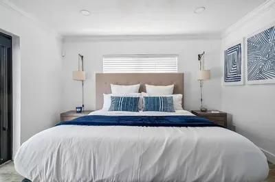 a bedroom with a large bed with blue and white sheets at 3-Bedroom Villa with Heated Pool and Tropical Yard in Hollywood Lakes in Hollywood