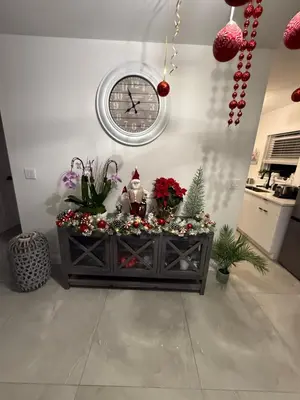 a clock on the wall above a table with christmas decorations at HOSTEL Star in Hallandale Beach