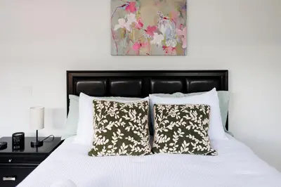 a bedroom with a bed with white sheets and pillows at Plumeria Housing in Fort Lauderdale