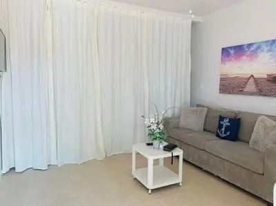 a living room with a couch and a table at Coastal Cabana in Hollywood