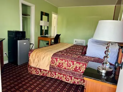 a hotel room with a bed and a desk at Vacation Inn motel - FT Lauderdale Airport and Cruise port in Fort Lauderdale