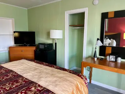 a hotel room with a bed and a mirror at Vacation Inn motel - FT Lauderdale Airport and Cruise port in Fort Lauderdale