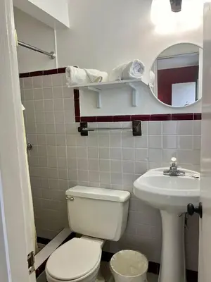 a bathroom with a white toilet and a sink at Vacation Inn motel - FT Lauderdale Airport and Cruise port in Fort Lauderdale