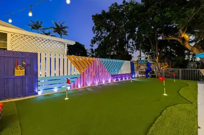 a playground with a green lawn with lights on it at Spacious 4BR Waterfront Home with Private Pool, Tiki Hut & Free Parking near Miami & Key Largo in Cutler Bay