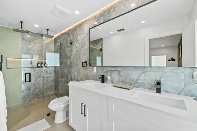 a bathroom with a white sink and a mirror at Spacious 4BR Waterfront Home with Private Pool, Tiki Hut & Free Parking near Miami & Key Largo in Cutler Bay