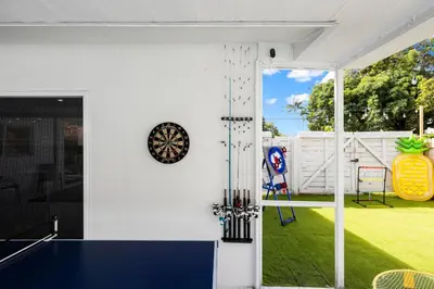 a house with a ping pong table in a yard at Spacious 4BR Waterfront Home with Private Pool, Tiki Hut & Free Parking near Miami & Key Largo in Cutler Bay